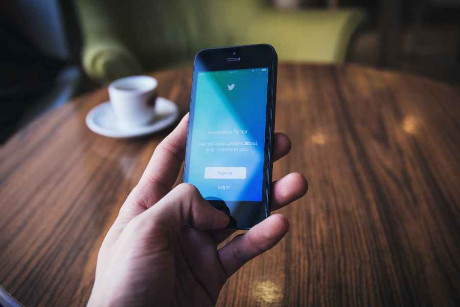 hand holding a phone with twitter on the screen
